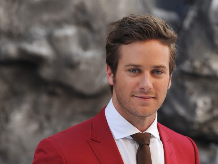 Armie Hammer piros öltönyben mosolyog