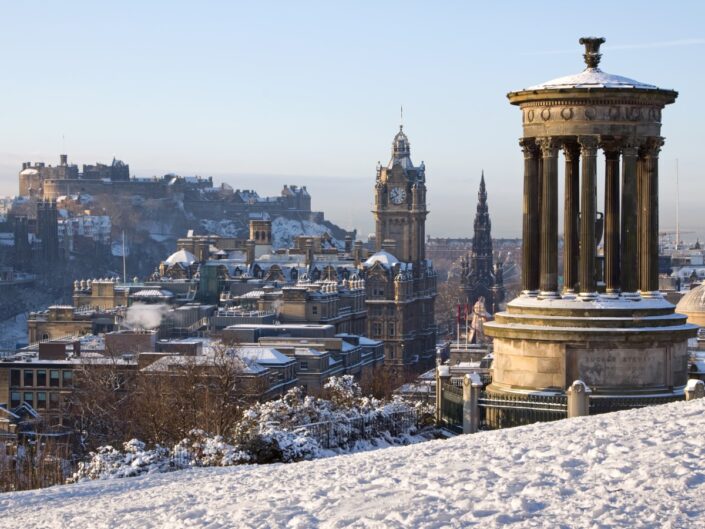 Edinburgh városa és vára a Calton Hillről egy gyönyörű téli reggelen, az előtérben a Dugald Stewart-emlékmű, a háttérben a vár, a Scott-emlékmű és a Balmoral óratorony