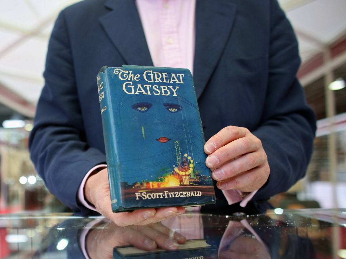 Egy eladó a The Great Gatsby első kiadásának egy példányát tartja kezében