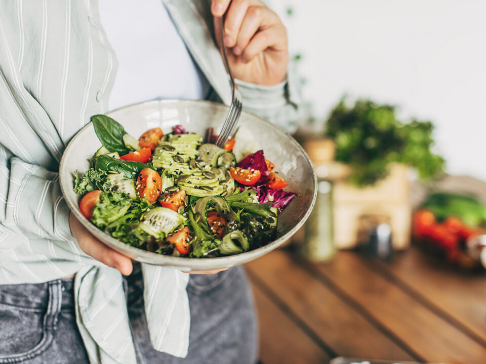 Woman mixing delicious superfood salad ingredients with wooden spoons in kitchen - Nők Lapja szezonalis-magyar-superfoodok