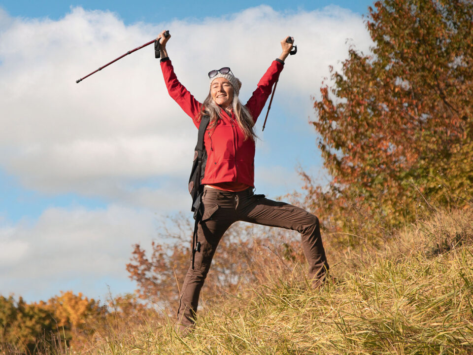 Smiling woman standing with hand raised on mountain against sky at Alpine Foothills Germany - Nők Lapja 3-csillagjegy-veszely-marcius