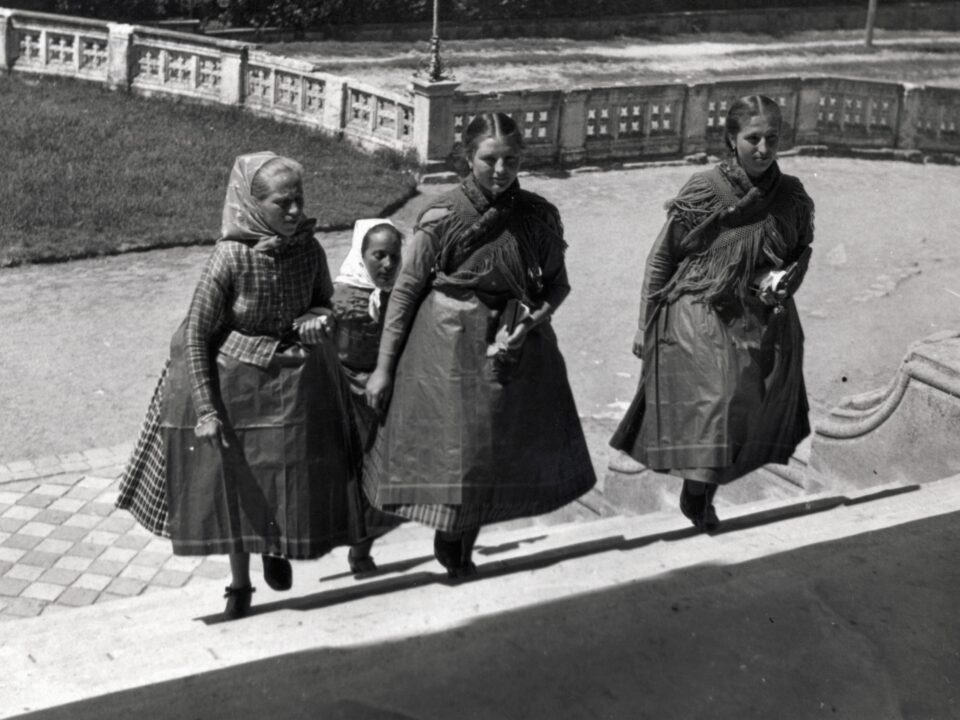 svab-jovevenyszavak-kviz - Nők Lapja fekete-fehér fotó 1936-ból, a fóti katolikus tmeplom lépcsőjén (a tmeplom nem látszik) négy leány megy fel sváb népviseletben
