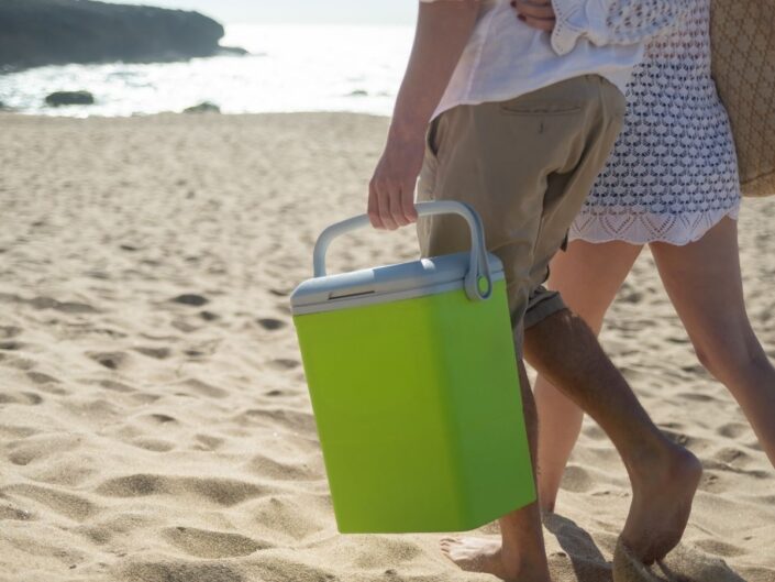 pár megy a tengerparton hűtőtáskával