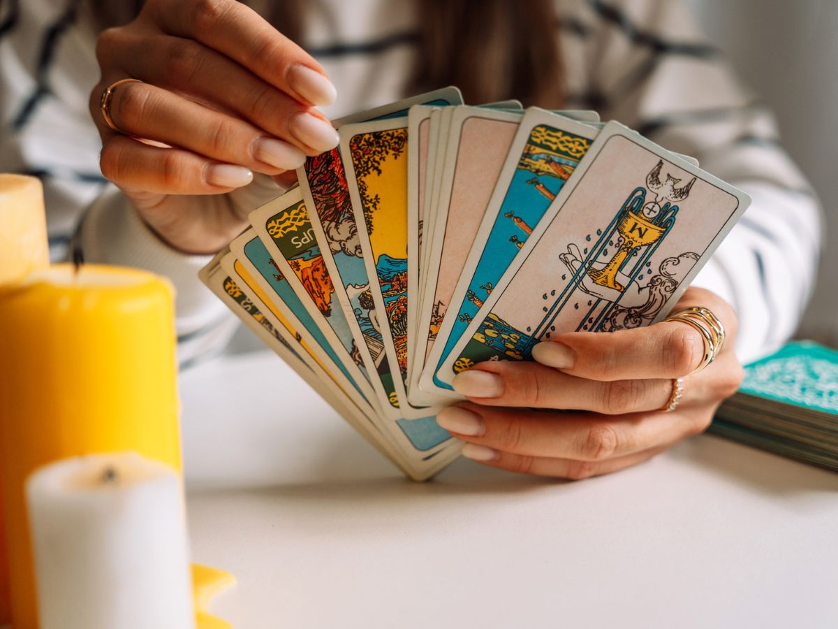 tarot kártya pakli nő kéz asztal gyertya