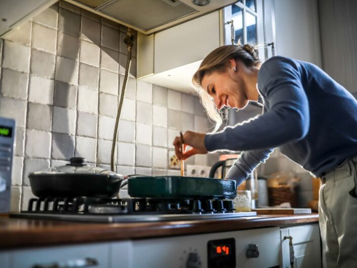 nő főz a konyhában