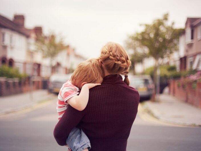 fiatal anyuka kicsi gyerekkel utcán háttal