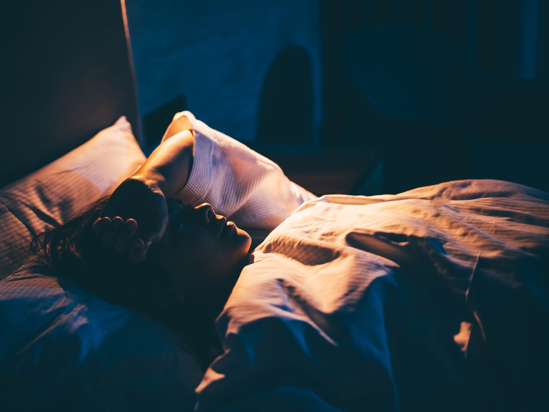 ágyban ébren fekvő nő