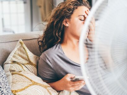 fiatal nő otthon ventilátor előtt hőség