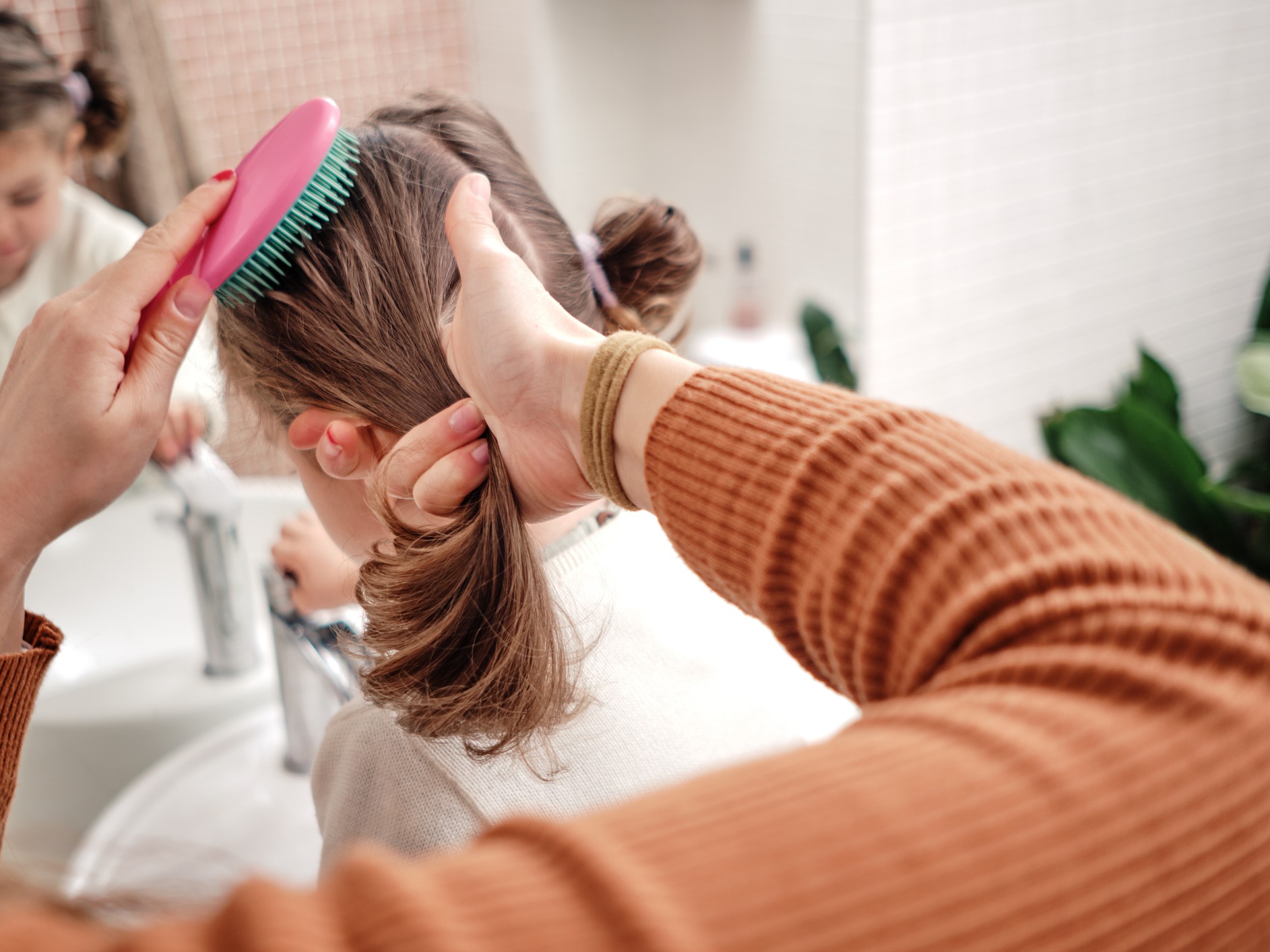 gyerek haját fésülő nő