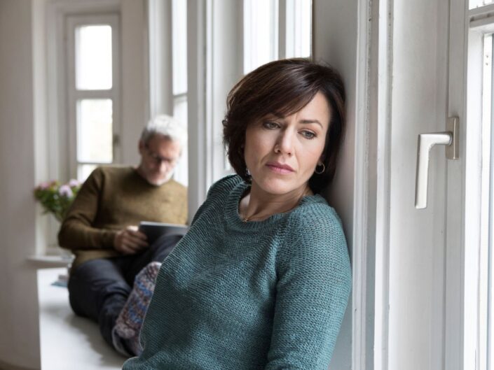 középkorú pár boldogtalan nő az ablakban