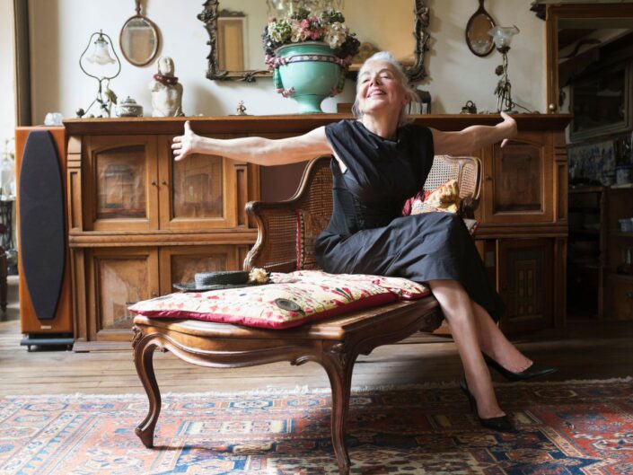 középkorú nő retró lakásban ül