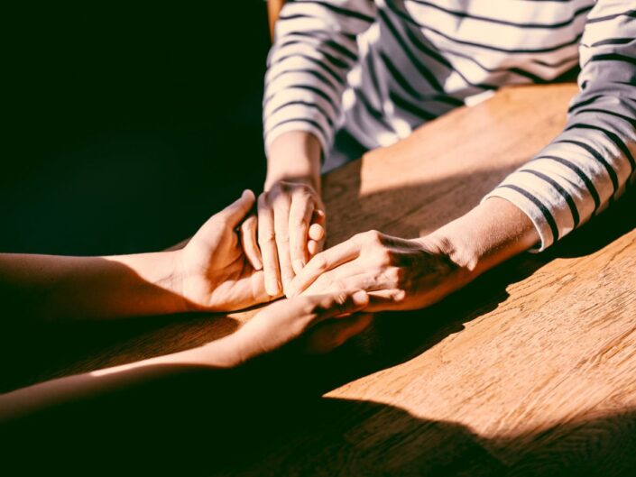 két barát keze egymáson asztal árnyék fény