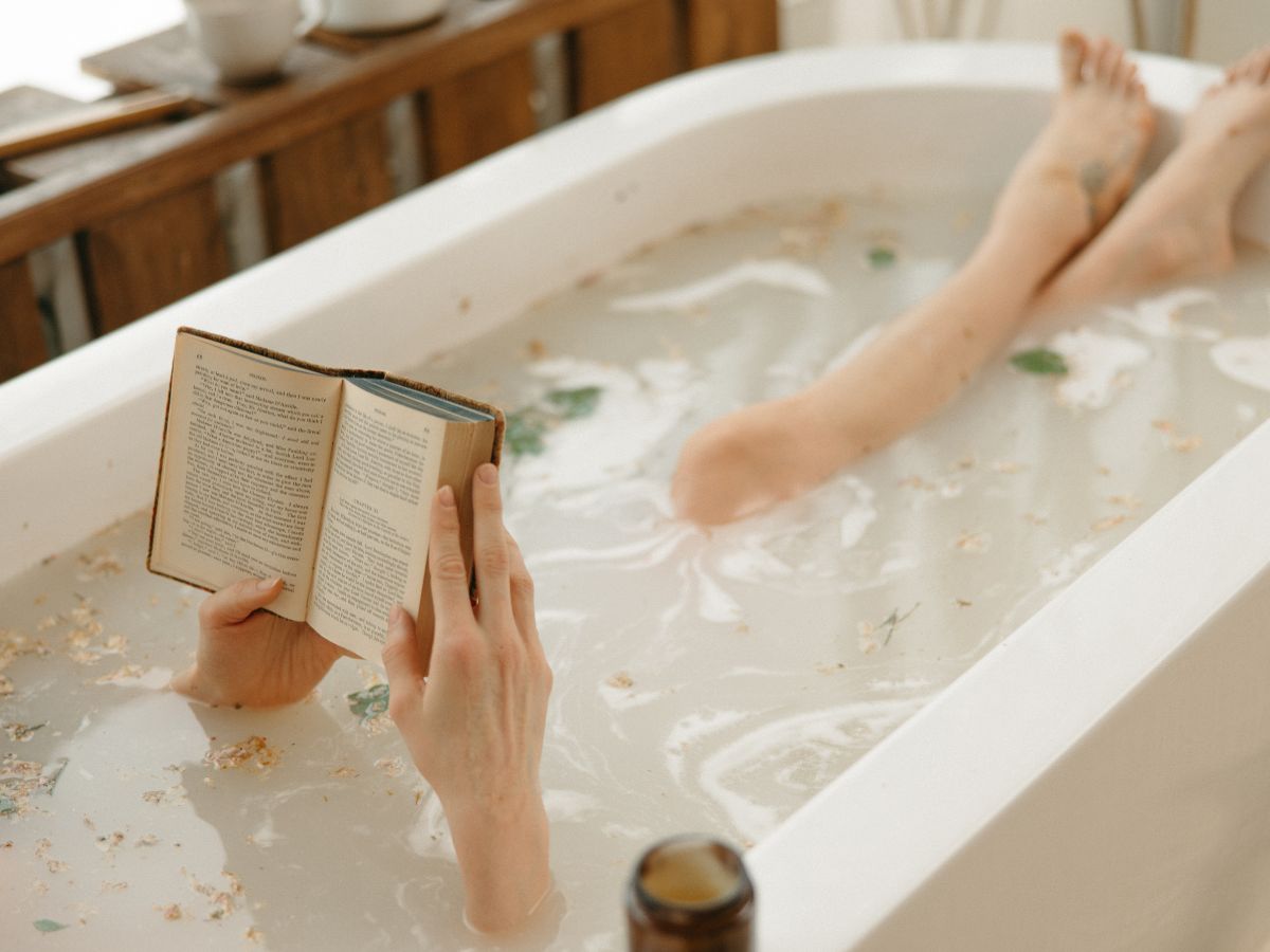 nő fürdőzik a kádban és olvas