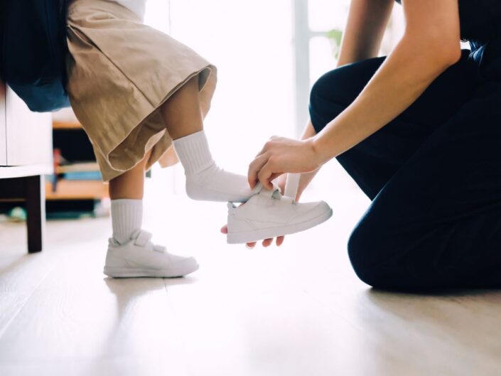 anyuka cipőt húz a gyereke lábára