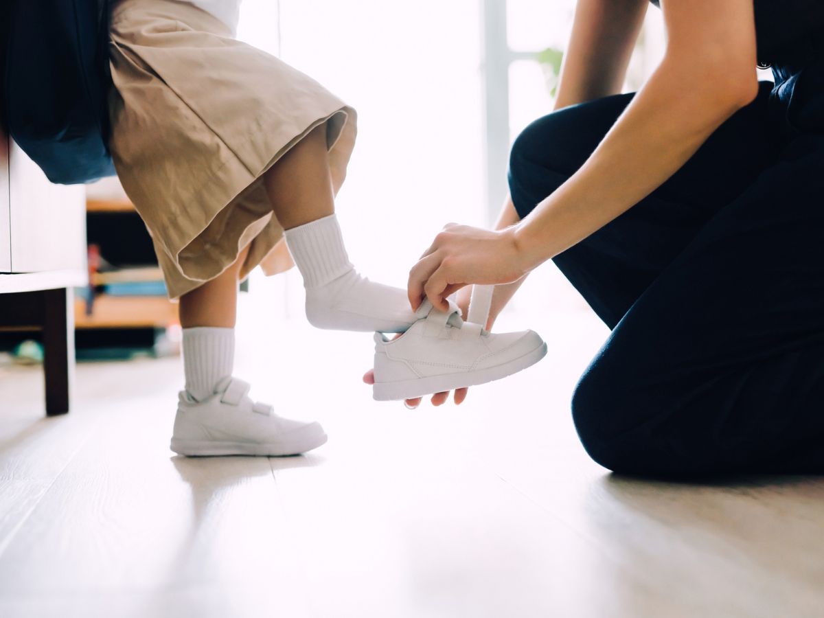 anyuka cipőt húz a gyereke lábára