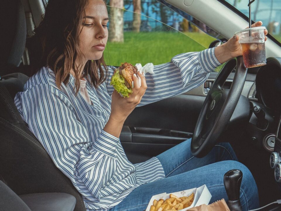 nő eszik a kocsiban