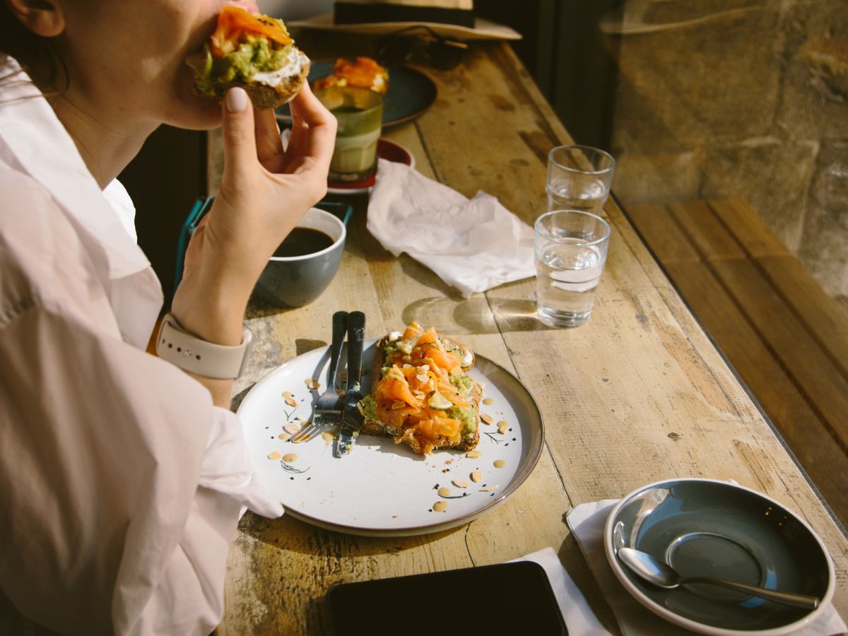 nő lazacos avokádós szendvicset eszik kávézó