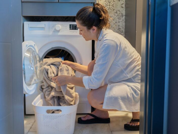 nő mos mosógép ruhák pakol kosár