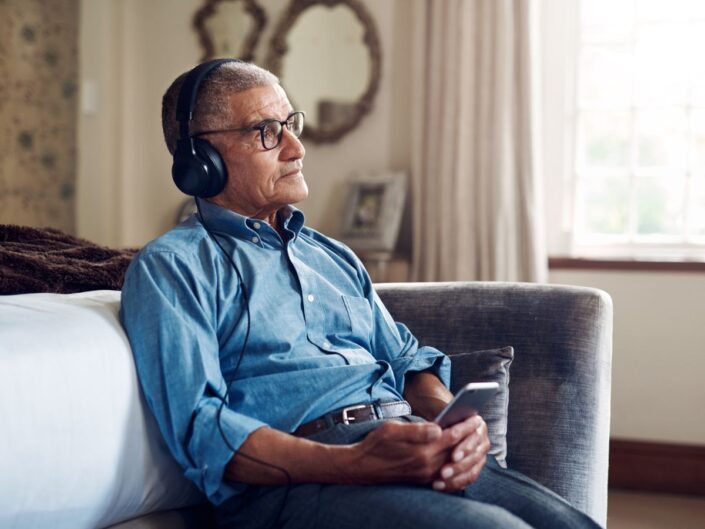 idős férfi kanapé fejhallgató merengés