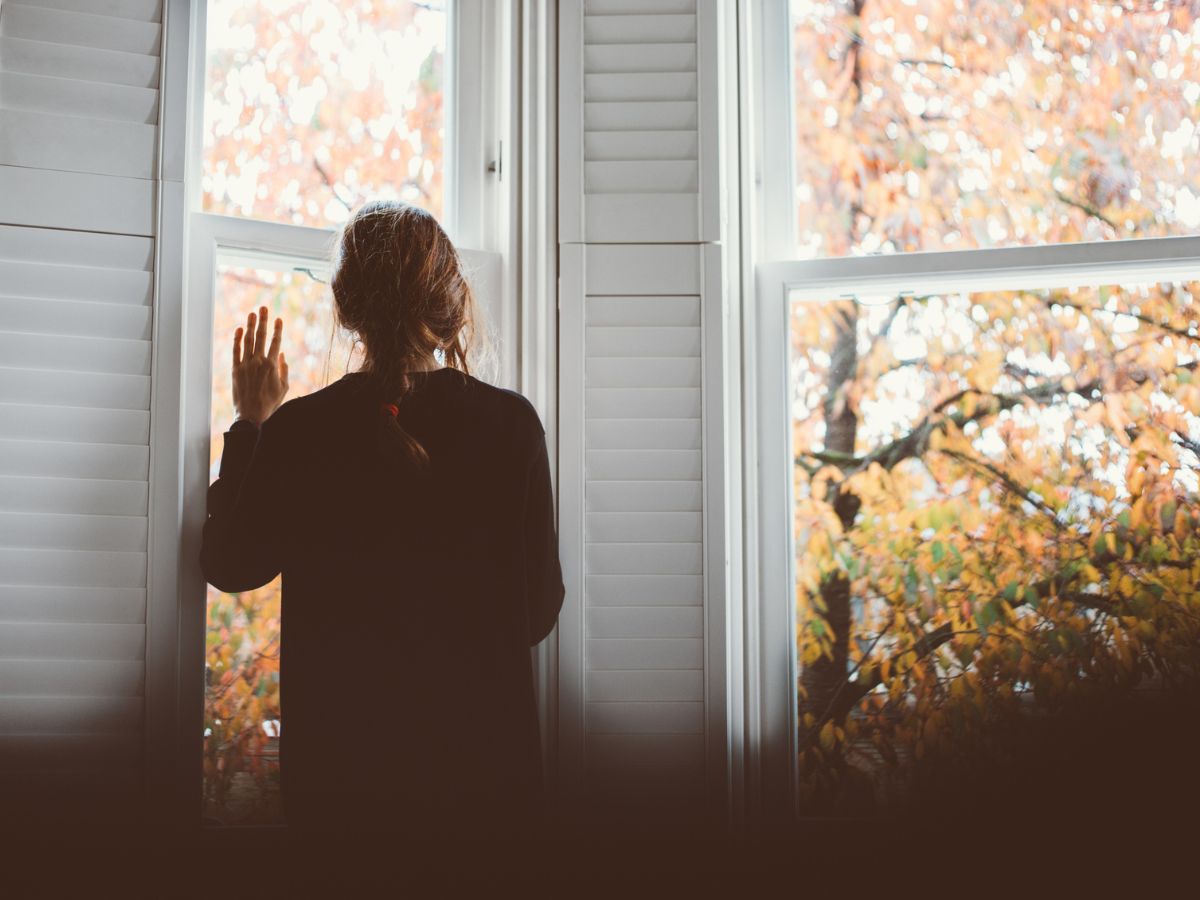 nő az ablak előtt ősszel