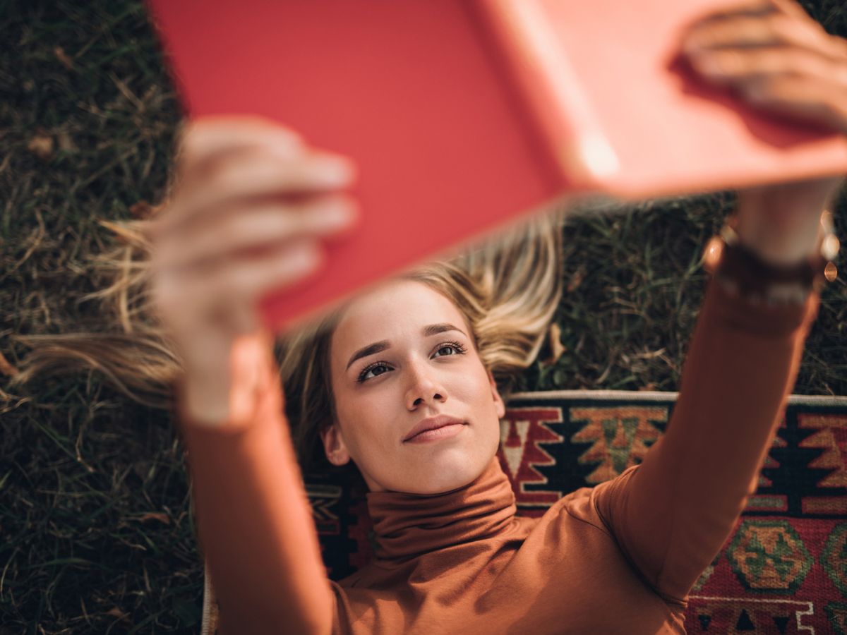 fiatal nő olvas piros könyv ősz