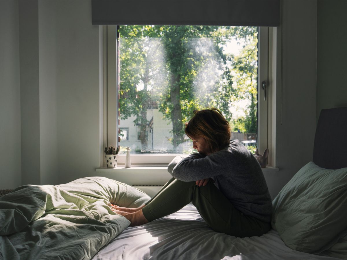 nő ágy ül szorongás otthon hálószoba