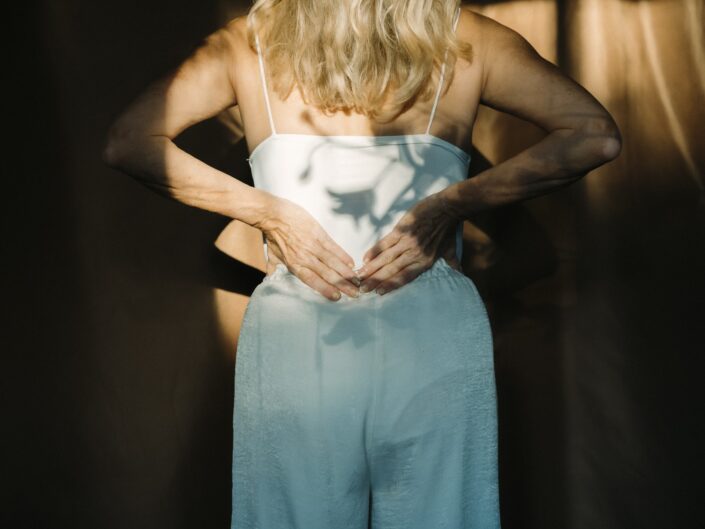 idősebb nő a derekát fogja