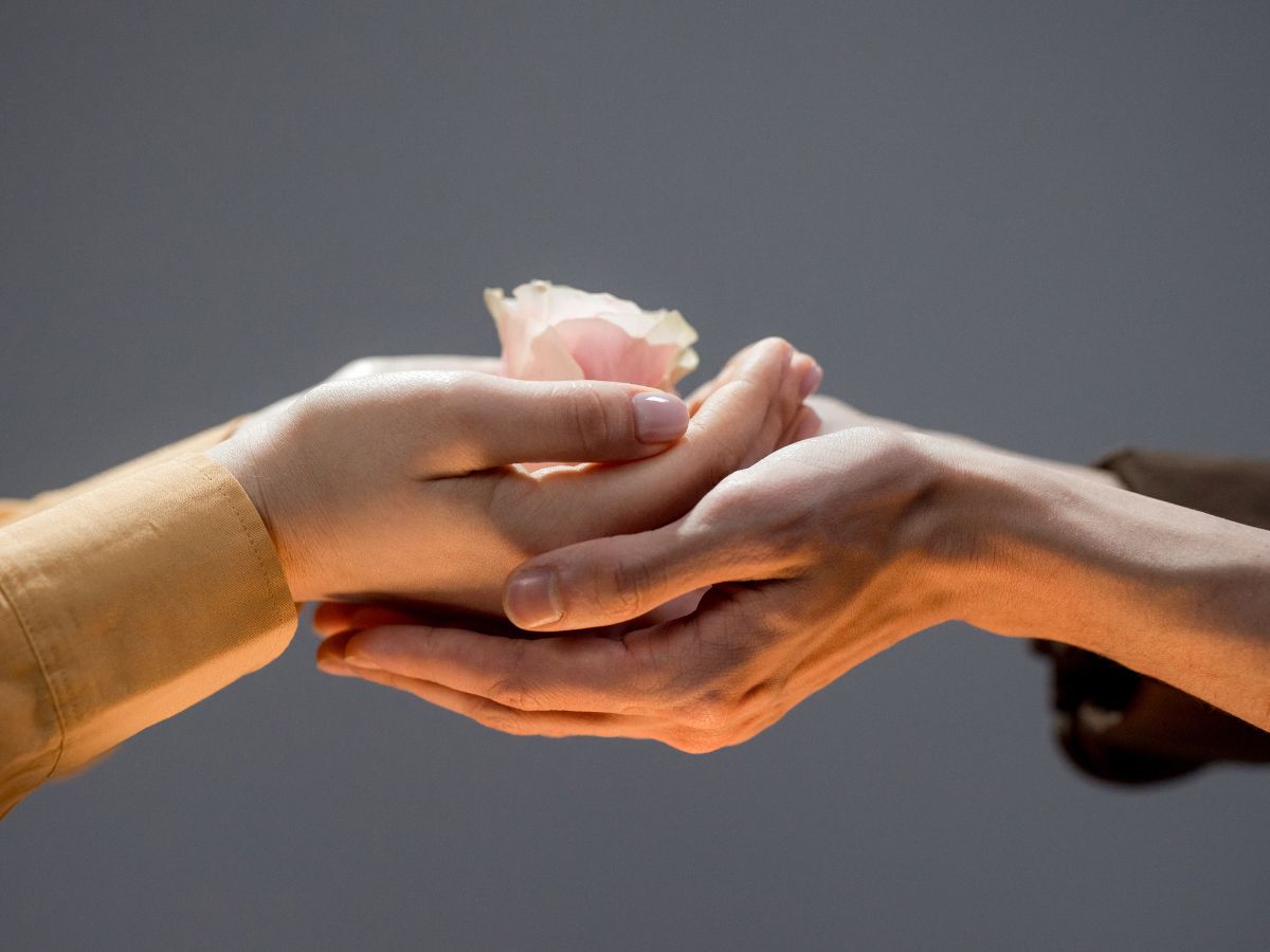 két kéz egymáson virágot tart