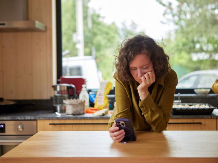nő otthon konyha mobiltelefon