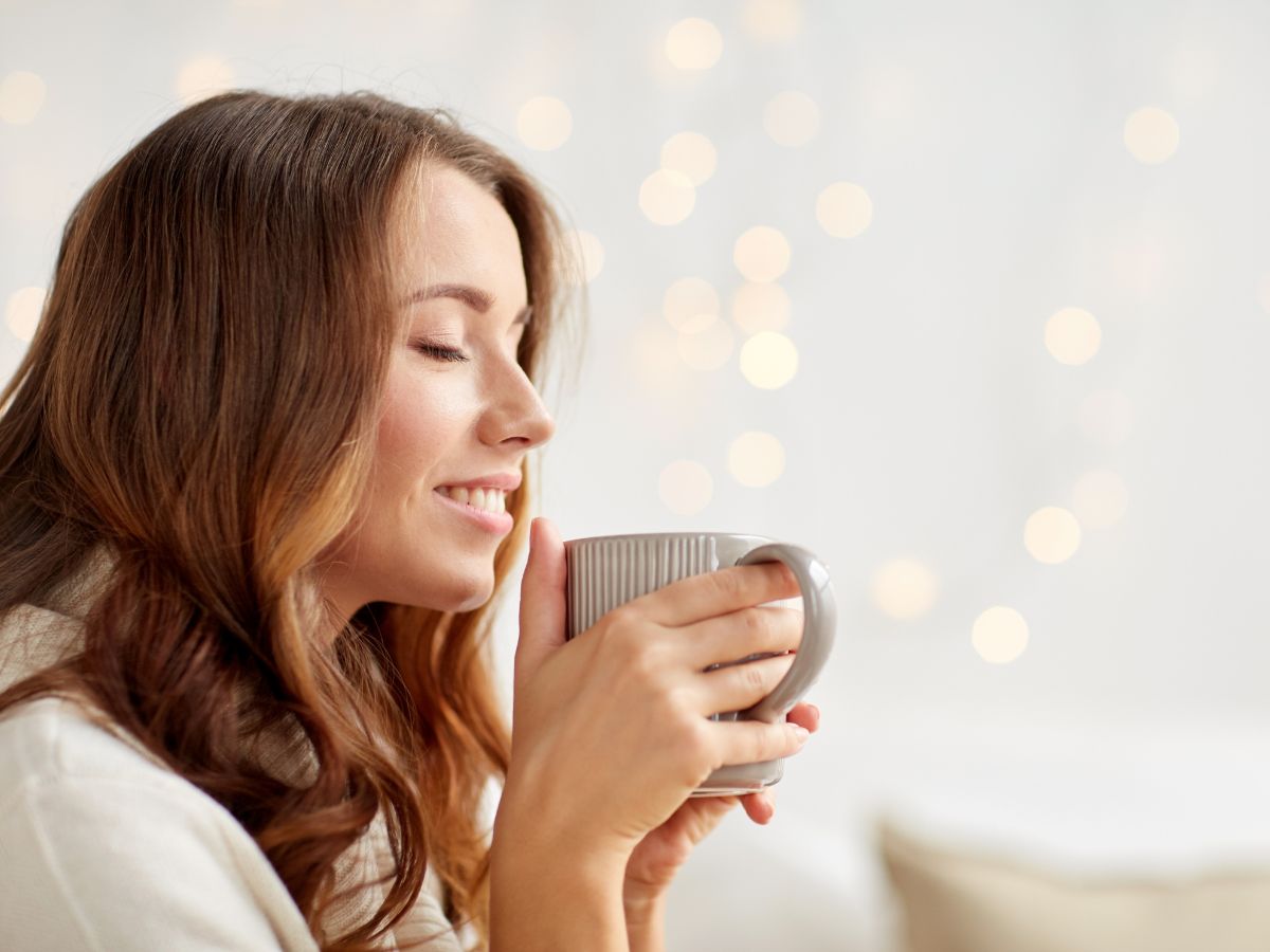 boldog nő bögrével világs szobában