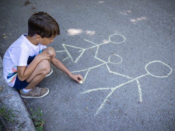 gyerek rajzol a földre