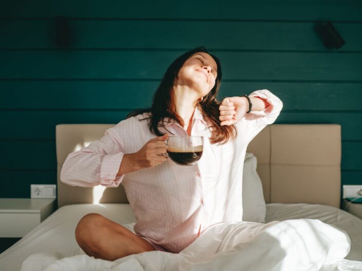 fiatal nő otthon ágy pizsama kávé napsütés reggel