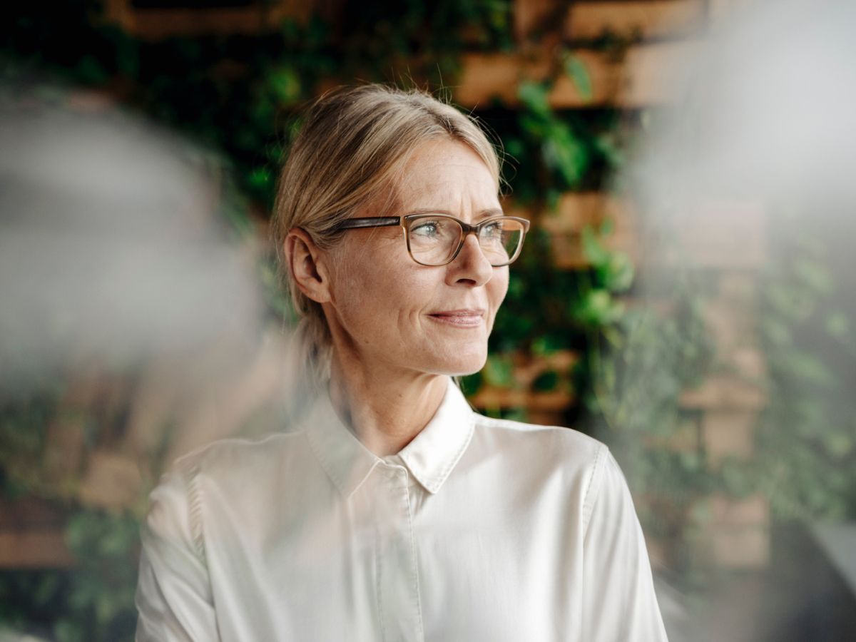 középkorú nő ablak fény iroda