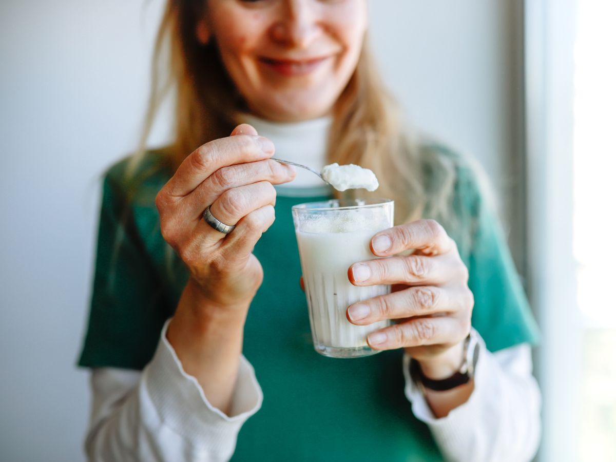 középkorú nő joghurt pohár evés