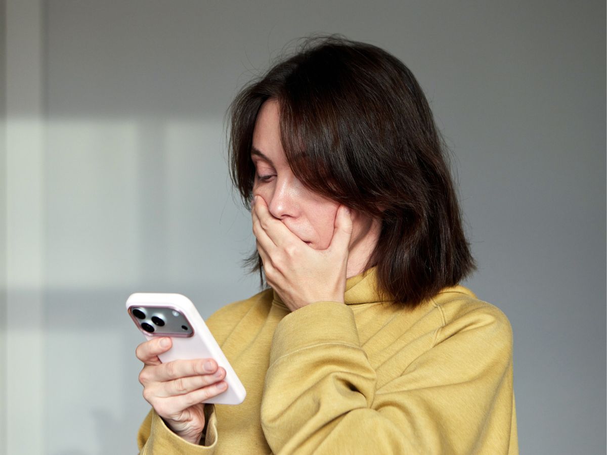 fiatal nő sárga pulóver telefon meglepődik aggódik