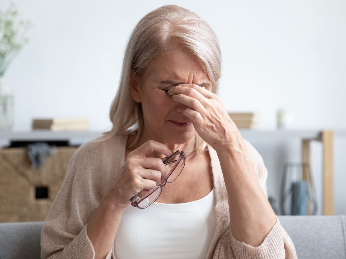 középkorú nő a szemét dörzsöli