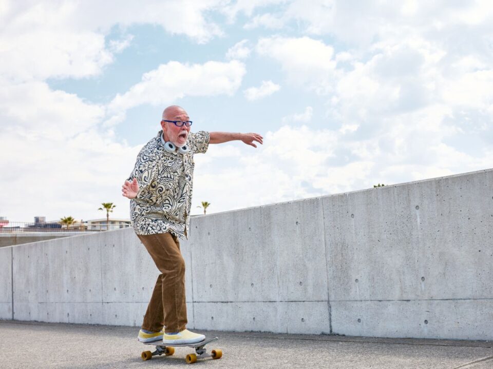 Stílusosan felöltözött gördeszkázó öreg férfi