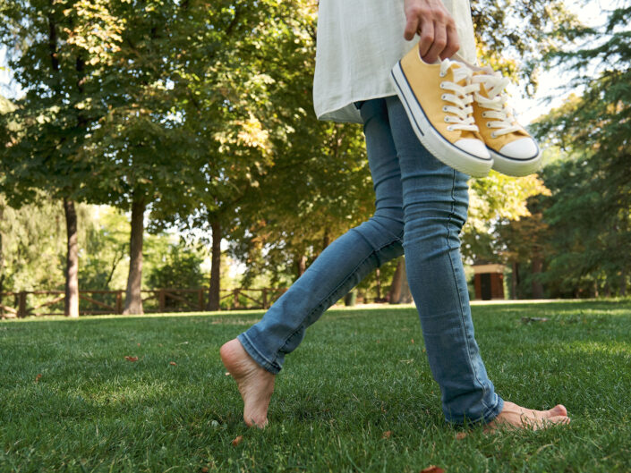 egy nő mezítláb jár a fűben