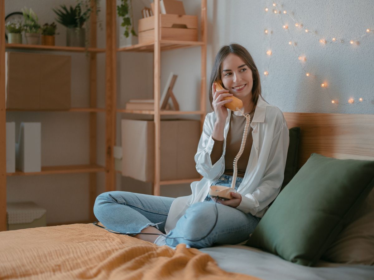 nő beszél egy ágyon vonalas telefonon