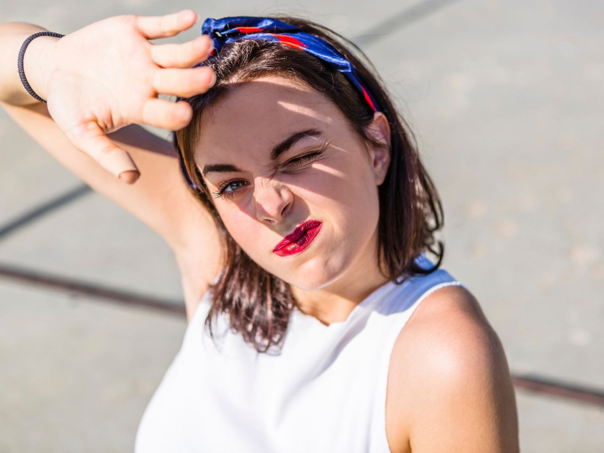 fiatal nő a szemét óvja az erős napsütéstől