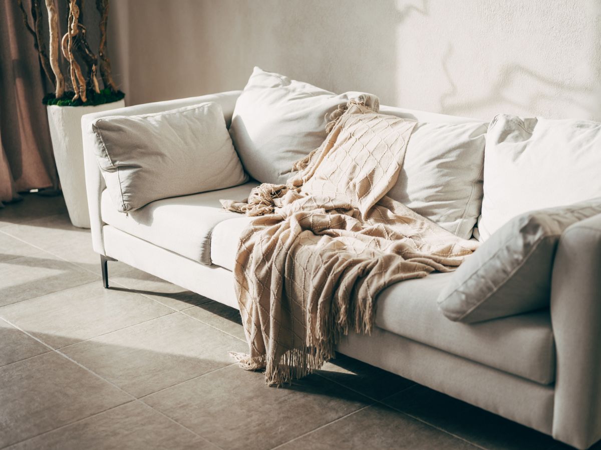 díszpárnák és takaró egy napfényes nappaliban