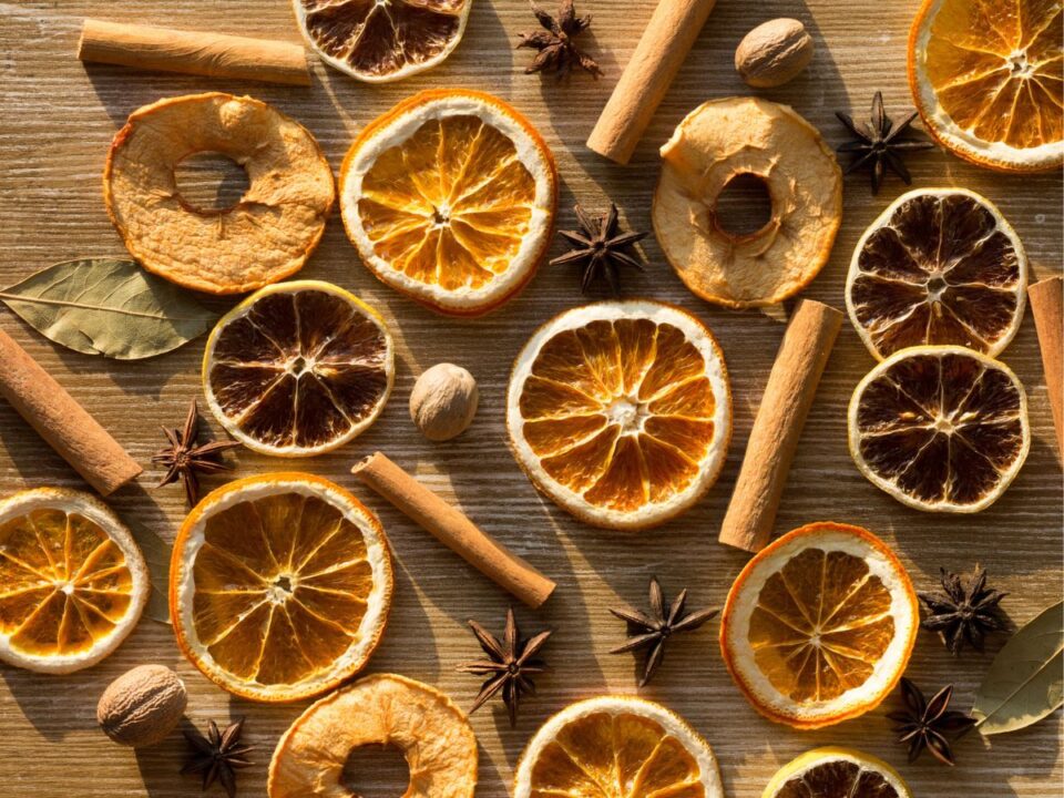 szárított narancs, alma, fahéj, babérlevél és csillagánizs egyvelege egy asztalon 