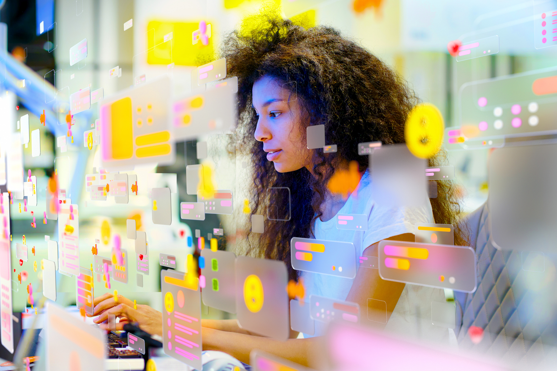 fiatal nő számítógép előtt körülötte színes képkockák adatok