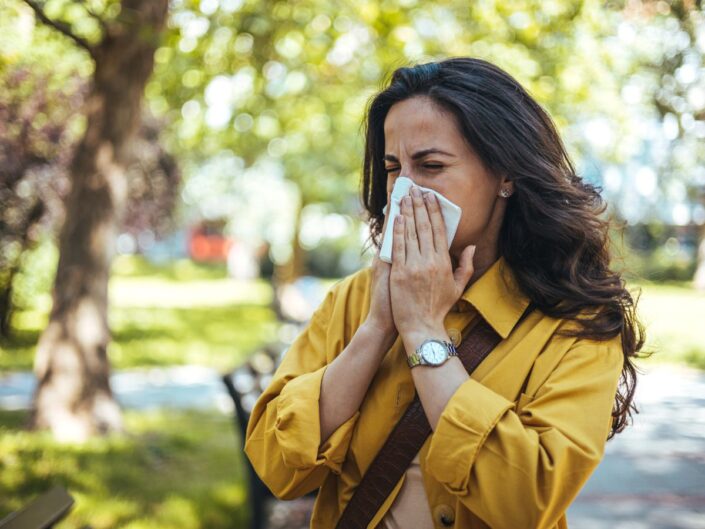 fiatal nő orrot fúj a szabadban