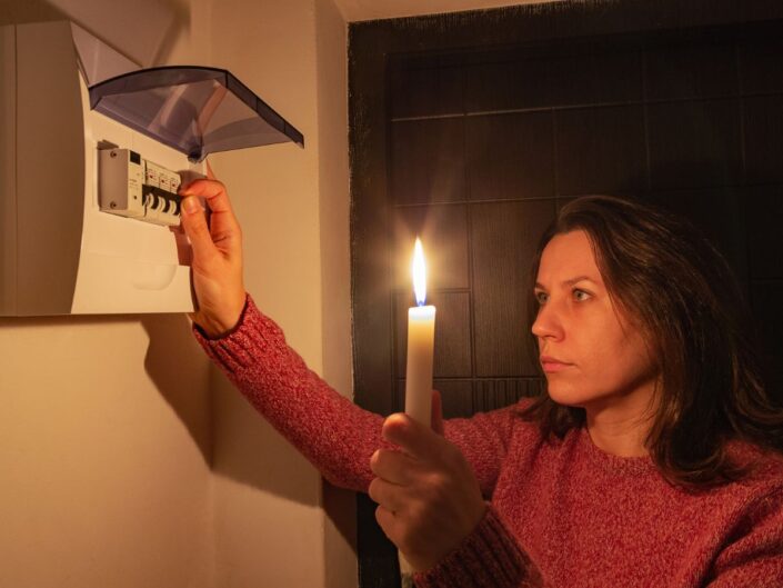 nő gyertyával felkapcsolja a biztosítékot