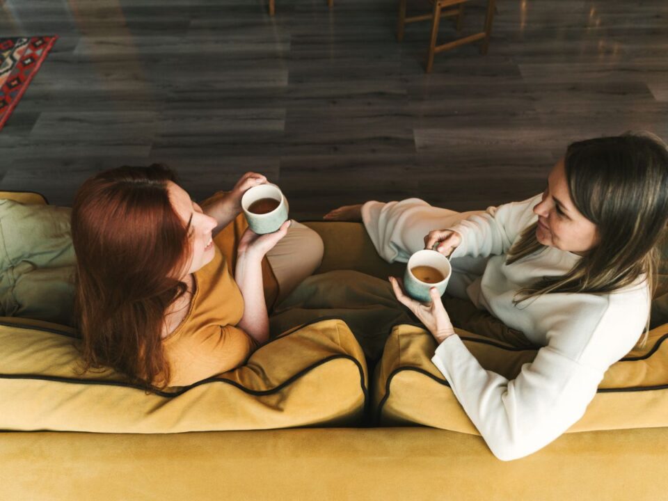 két nő kávézik és beszélget a kanapén