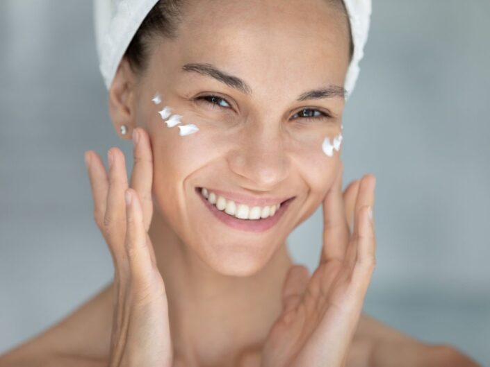 fiatal nő krémezi az arcát