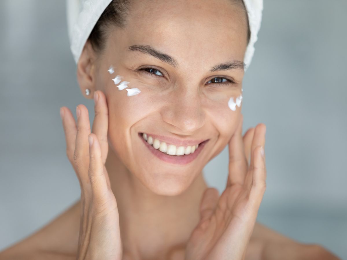fiatal nő krémezi az arcát