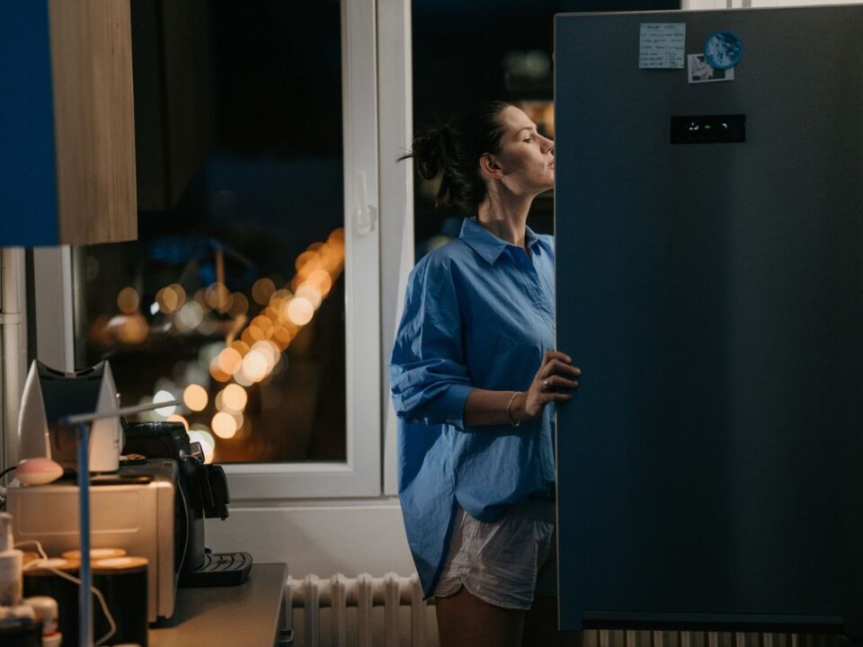 nő nézi a hűtő tartalmát