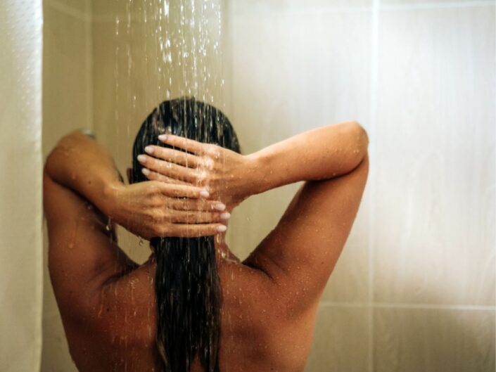 fiatal nő hajat mos a zuhany alatt